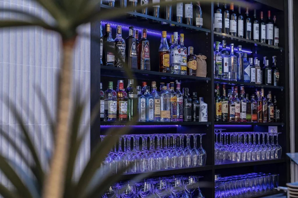 pared con botellas para cocteles en Frenesí