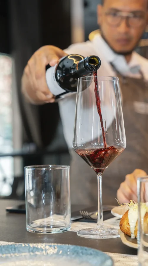 camarero sirviendo vino tinto